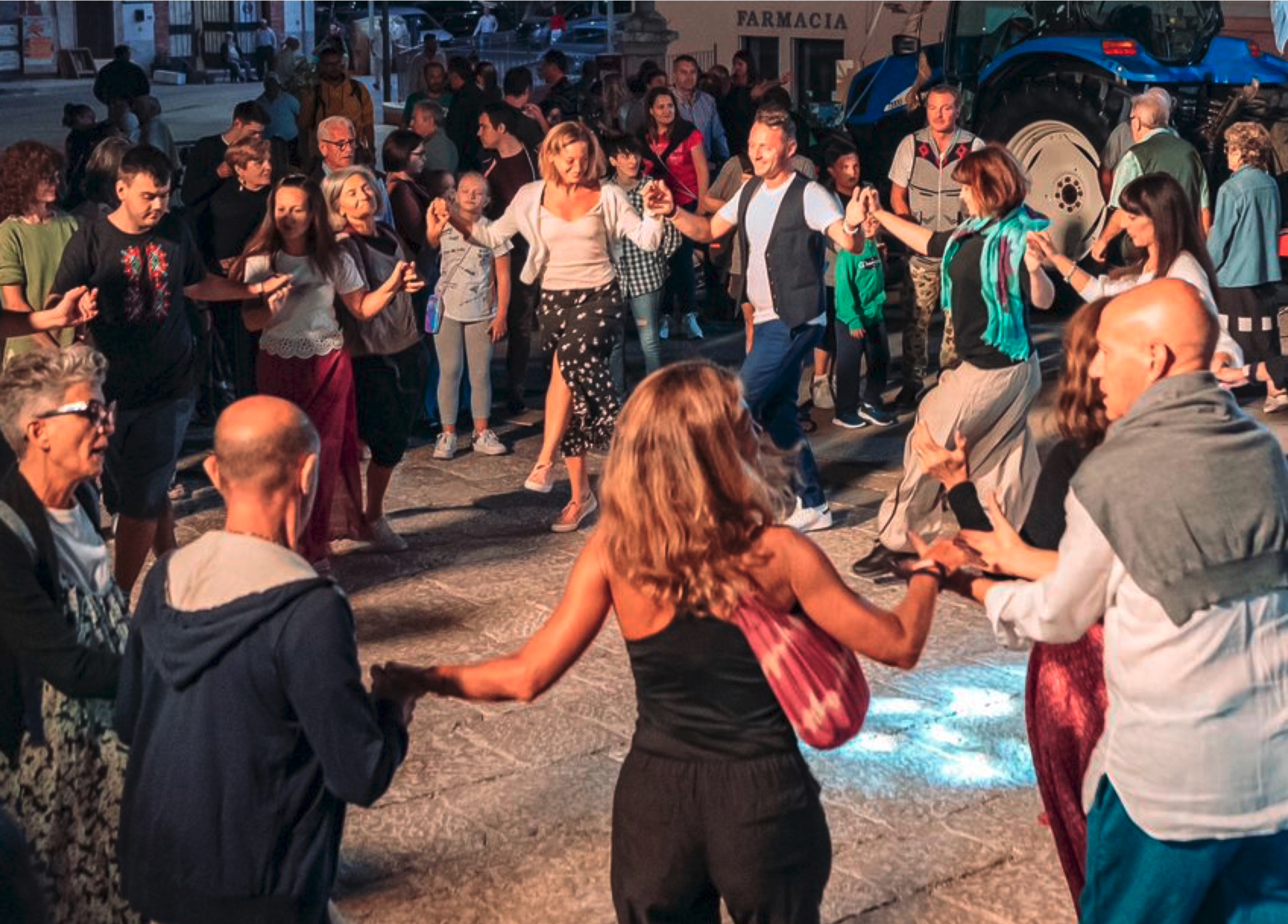 Back of a man at a concert. Hes wearing a beanie hat and a baggy denim jacket with studs. Photo with a purple hue