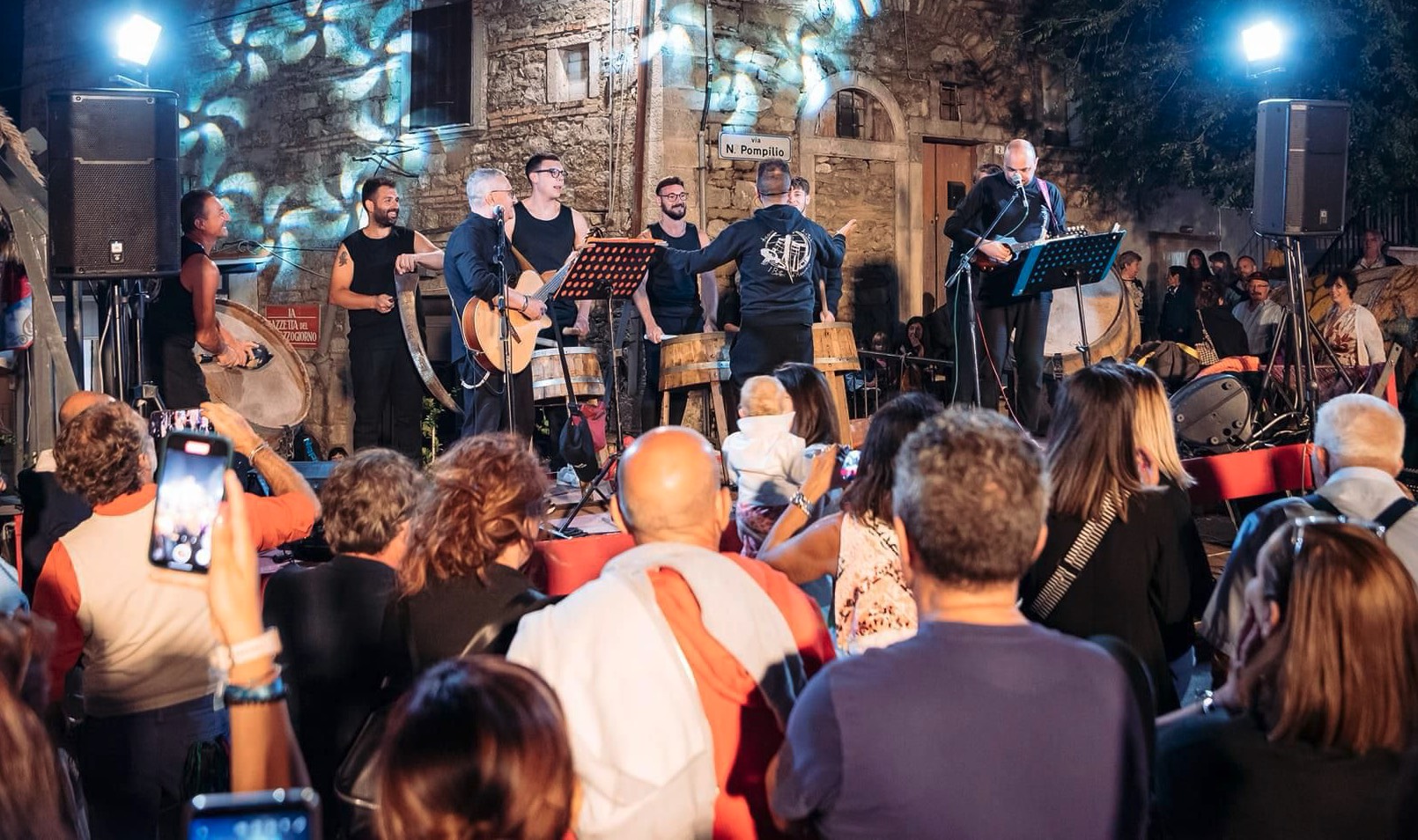DJ facing a crowd at his deck. Photo with a purple hue